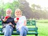 portrait-smiling-senior-couple-sitting-bench-park