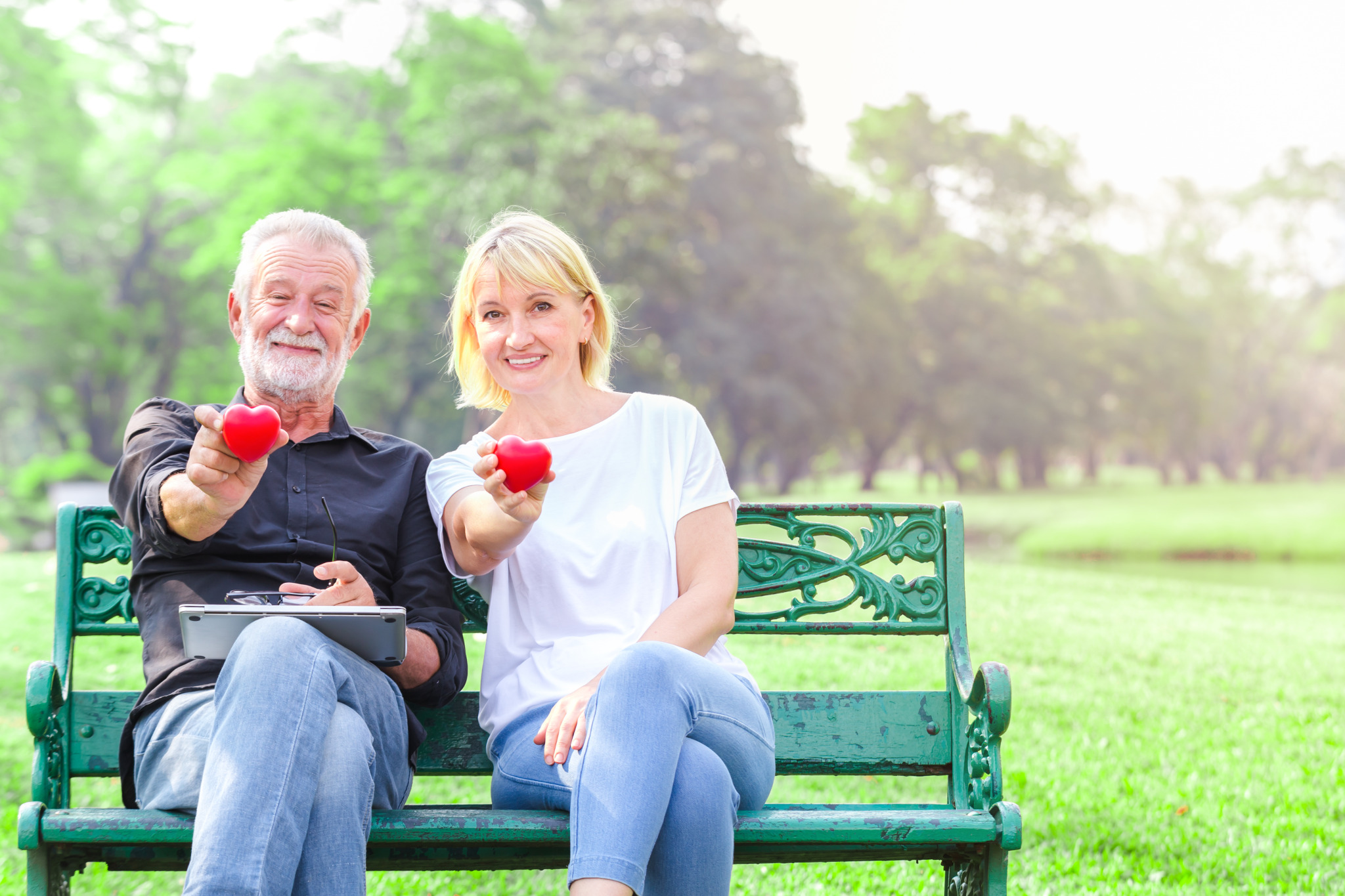 portrait-smiling-senior-couple-sitting-bench-park